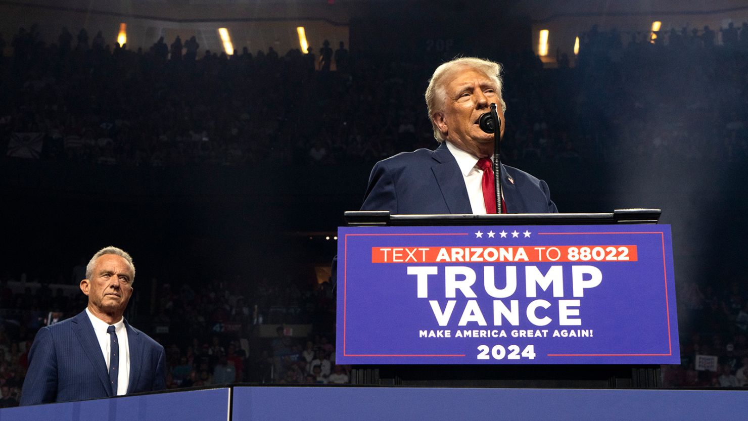 Republican presidential nominee, former U.S. President Donald Trump (R) speaks as former presidential candidate Robert F. Kennedy Jr. listens during a campaign rally at Desert Diamond Arena on August 23, 2024 in Glendale, Arizona.