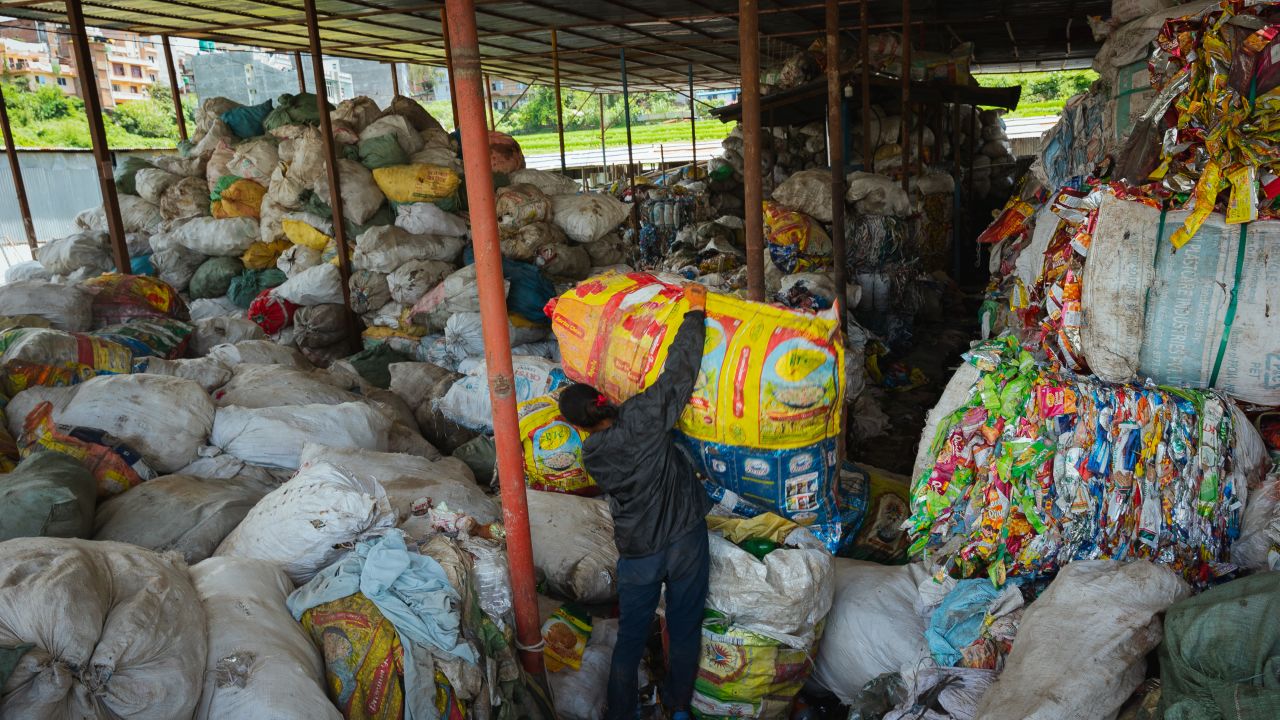 KATHMANDU, NEPAL - AUGUST 18: A worker hoists a bag full of recycling at Avni recycling plant on August 18, 2024 in Kathmandu, Nepal. Avni Ventures is a green social business based in Kathmandu that is pioneering the circular economy in Nepal through PET collection and recycling, green technology R&D, sustainability education, and consultancy services. As the largest responsible plastic waste collection and recycling network in Nepal, Avni has created a formal supply chain, supported waste entrepreneurs, and partnered with local governments to reduce CO2 emissions and eliminate child labor in the waste sector. The company is also the official recycling partner of the Mountain Clean Up Campaign, led and coordinated by the Nepali Army, in charge of sorting and processing the recyclable waste collected from Mount Everest, the world's tallest mountain.  (Photo by Mailee Osten-Tan/Getty Images)