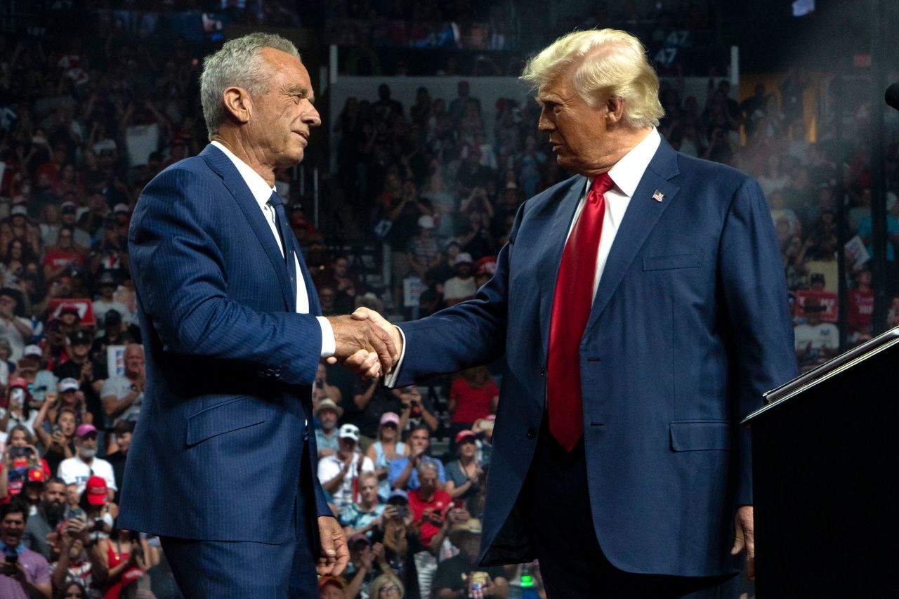 Robert F. Kennedy Jr. and former President Donald Trump shake hands during a campaign rally at Desert Diamond Arena on August 23, 2024 in Glendale, Arizona. 