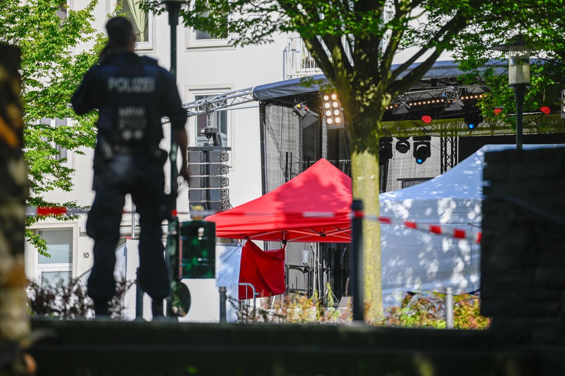 Police investigators stand at the site of yesterday's deadly stabbings that left three dead and eight injured in Solingen, Germany.