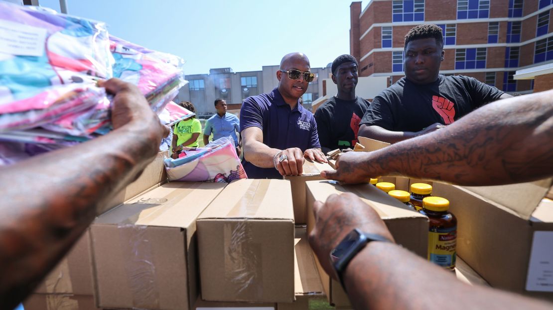 Jackson State University President Marcus Thompson, center, joins Black Men United in welcoming the families and friends of first-year and transfer students by distributing supply kits and other essentials on move-in day on August 10.