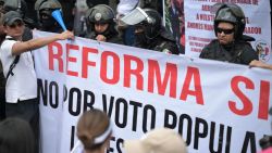 Police officers stand guard as employees of the Judiciary, who are on an indefinite strike, protest in front of the Supreme Court of Justice in Mexico City on August 25, 2024. Judicial Branch workers, judges, and magistrates held a nation-wide protest against a controversial constitutional reform with which the leftist government seeks to have them elected by popular vote. (Photo by Yuri CORTEZ / AFP) (Photo by YURI CORTEZ/AFP via Getty Images)