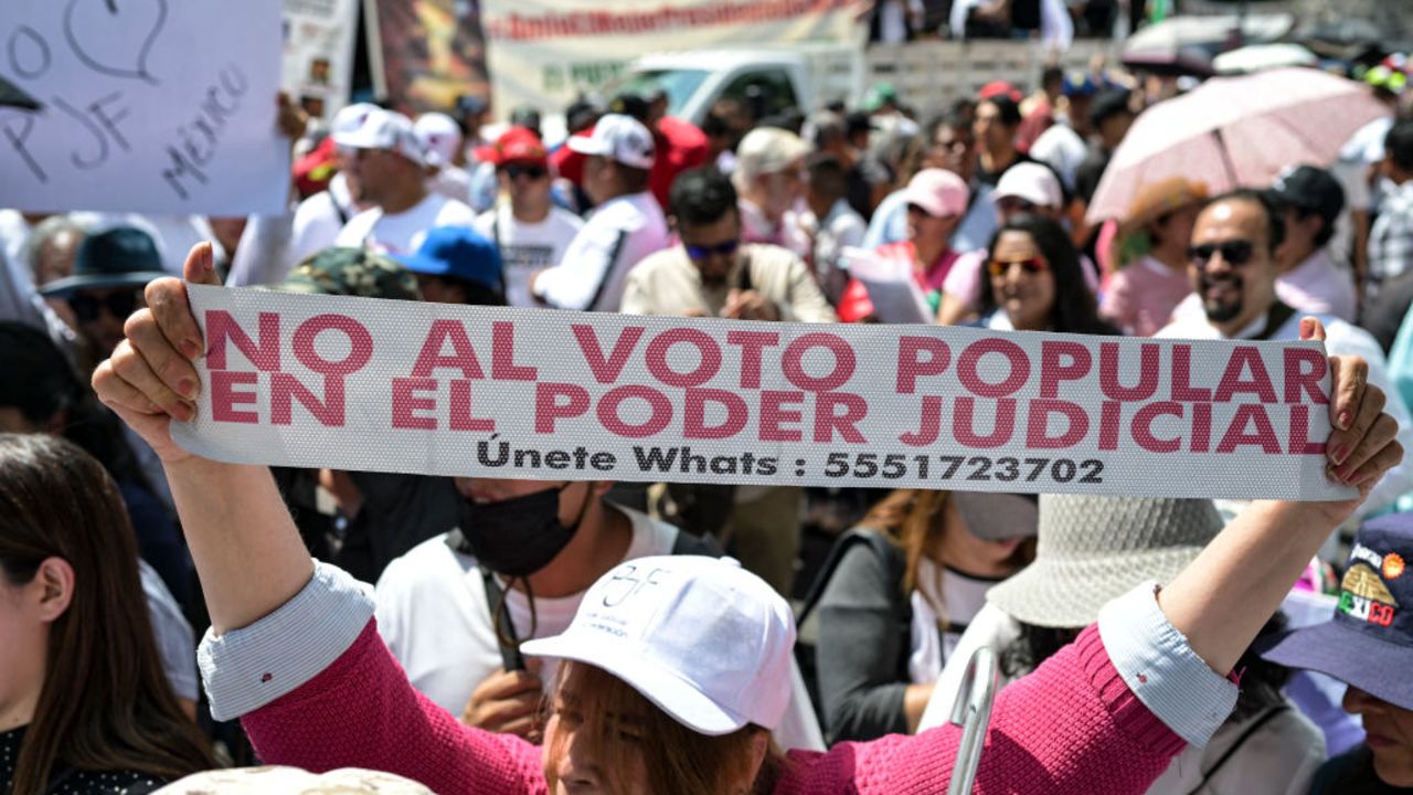 A woman holds a sign as employees of the Judiciary, who are on an indefinite strike, protest in front of the Supreme Court of Justice in Mexico City on August 25, 2024. Judicial Branch workers, judges, and magistrates held a nation-wide protest against a controversial constitutional reform with which the leftist government seeks to have them elected by popular vote. (Photo by Yuri CORTEZ / AFP) (Photo by YURI CORTEZ/AFP via Getty Images)