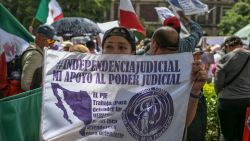 A woman holds a sign as employees of the Judiciary, who are on an indefinite strike, protest in front of the Supreme Court of Justice in Mexico City on August 25, 2024. Judicial Branch workers, judges, and magistrates held a nation-wide protest against a controversial constitutional reform with which the leftist government seeks to have them elected by popular vote. (Photo by Yuri CORTEZ / AFP) (Photo by YURI CORTEZ/AFP via Getty Images)