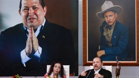 This handout picture released by the Nicaraguan Presidency shows Nicaraguan President Daniel Ortega (R) speaking next to his wife and Vice President Rosario Murillo and in front of a giant photo of the late Venezuelan former president Hugo Chavez (L-back) during the XI ALBA-T Extraordinary Summit (virtual) in Managua on August 26, 2024. (Photo by Cesar PEREZ / Nicaraguan Presidency / AFP) / RESTRICTED TO EDITORIAL USE - MANDATORY CREDIT "AFP PHOTO / NICARAGUAN PRESIDENCY / CESAR PEREZ" - NO MARKETING NO ADVERTISING CAMPAIGNS - DISTRIBUTED AS A SERVICE TO CLIENTS (Photo by CESAR PEREZ/Nicaraguan Presidency/AFP via Getty Images)