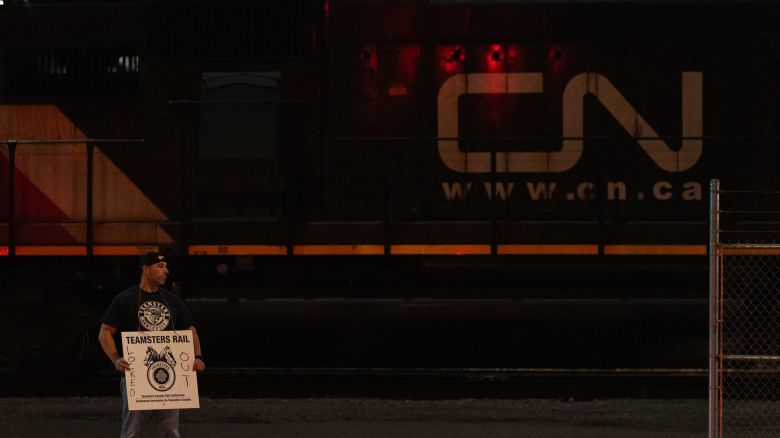 A Teamsters union member holds a picket sign at the entrance of CN Rail Lynn Creek Yard in North Vancouver, British Columbia, Canada on Wednesday.