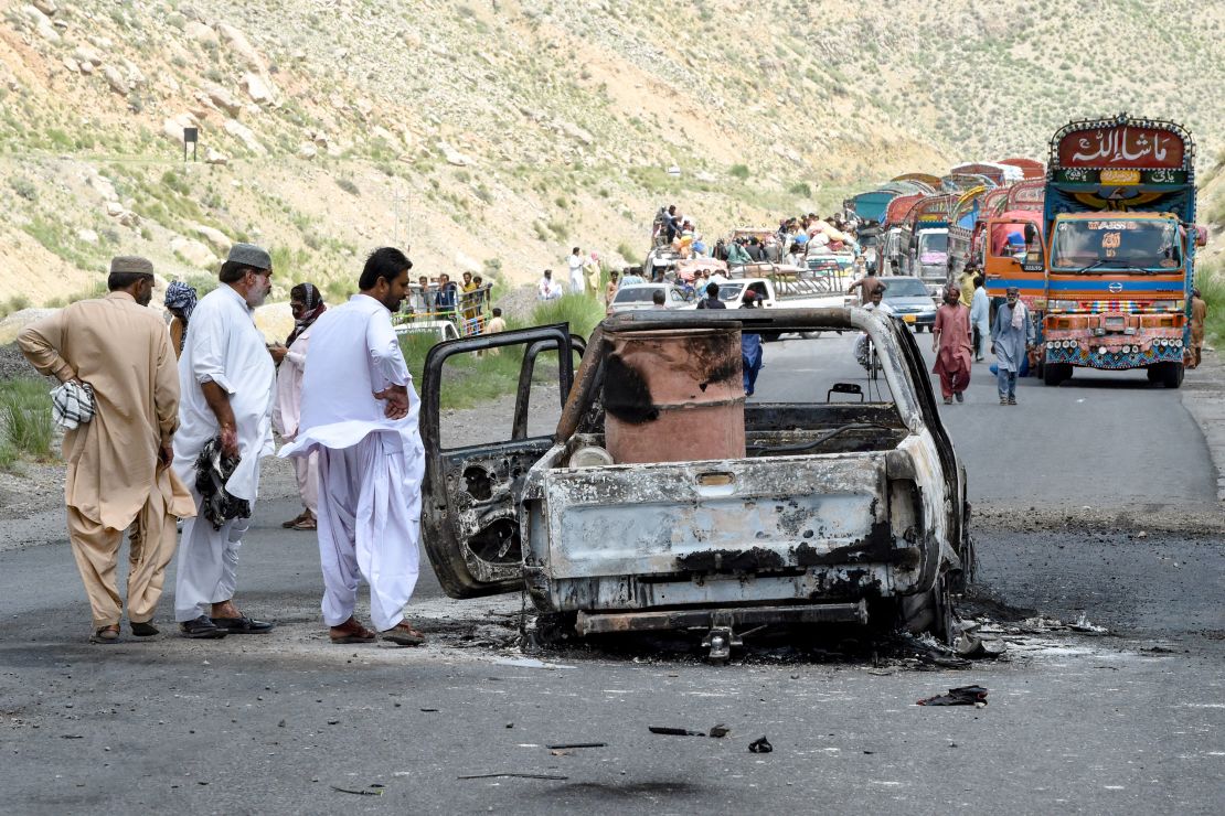 TOPSHOT - People look at a charred vehicle near a collapsed railway bridge the morning after a blast by separatist militants at Kolpur in Bolan district, Balochistan province on August 27, 2024. Pakistani forces hunted separatist militants on August 27, who killed dozens when they pulled passengers off buses, blew up a bridge and stormed a hotel a day earlier. Militants in Balochistan took control of a highway and shot dead 23 people, mostly labourers from neighbouring Punjab province, attacked the hotel and the railway bridge which connects Balochistan to the rest of Pakistan. (Photo by Banaras KHAN / AFP) (Photo by BANARAS KHAN/AFP via Getty Images)