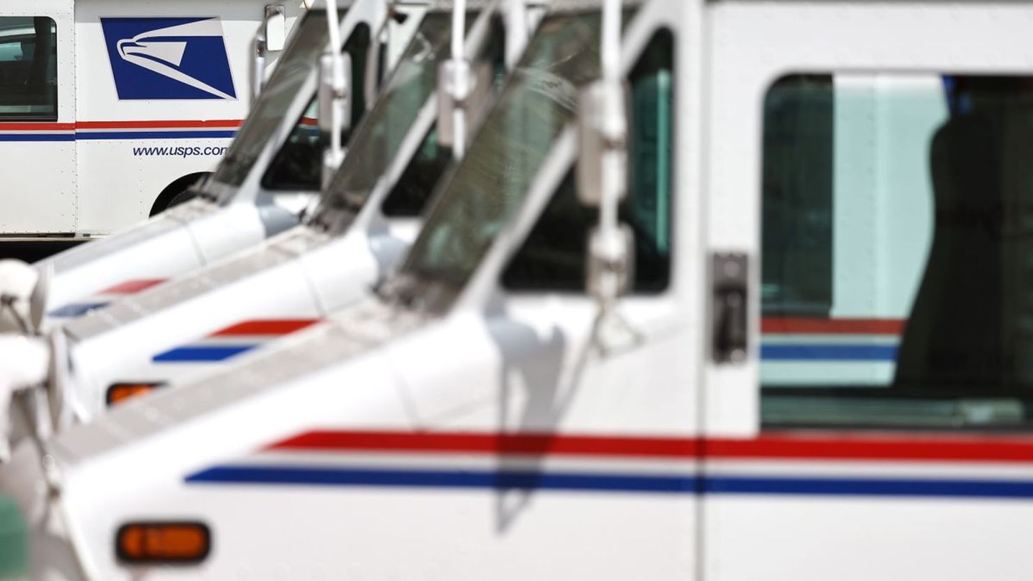 Camiones del Servicio Postal de Estados Unidos estacionados en una oficina de correos en Glendale, California.