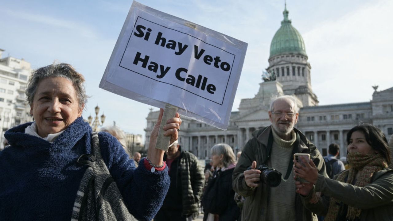 A pensioner demonstrator holds a sign that reads in spanish "If there is Veto, there is street" as she takes part in a protest  against Argentine President Javier Milei's veto of the pension mobility law in front of the National Congress in Buenos Aires on August 28, 2024. (Photo by JUAN MABROMATA / AFP) (Photo by JUAN MABROMATA/AFP via Getty Images)