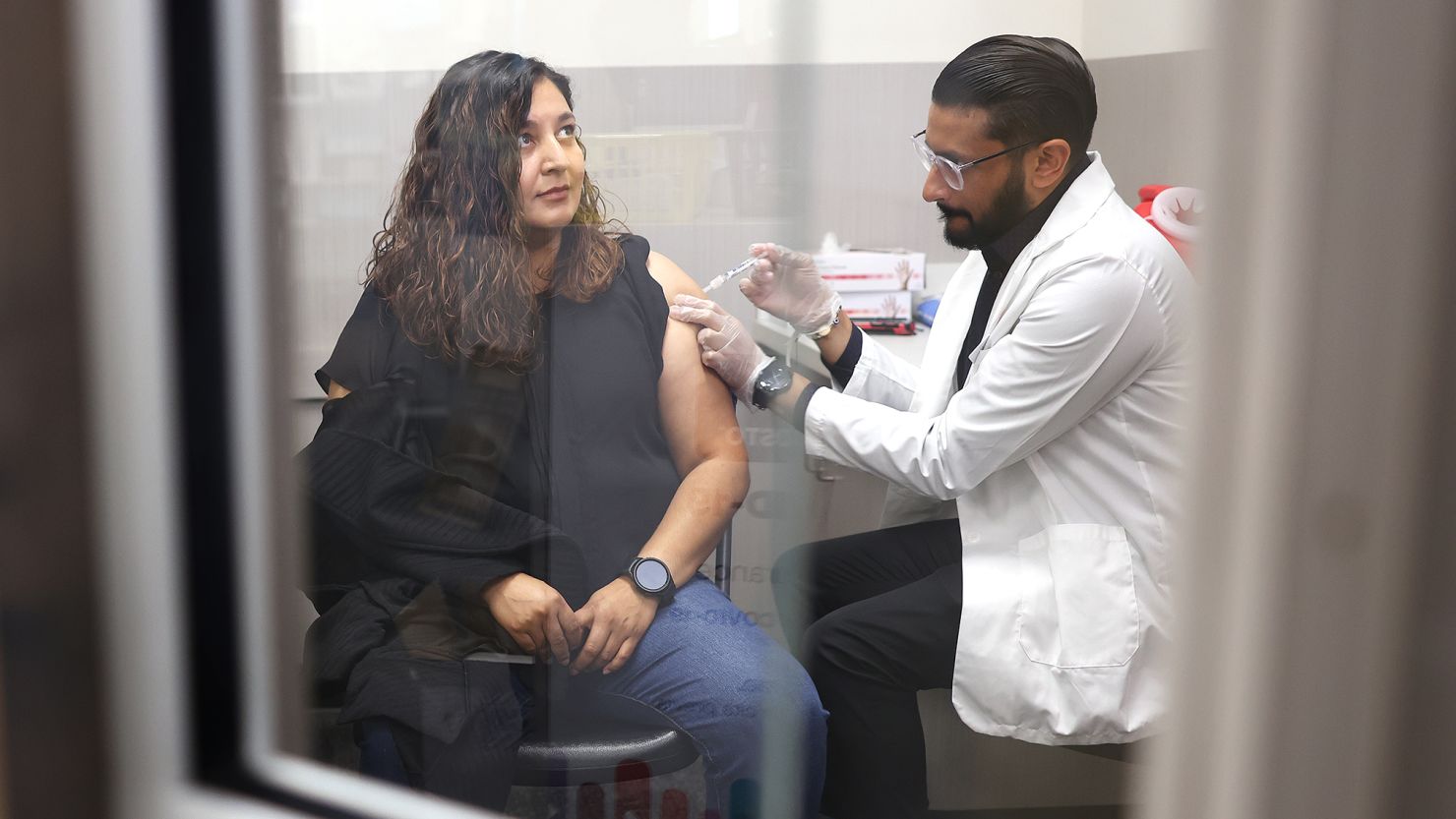 HUNTINGTON PARK-CA-AUGUST 28, 2024: Cynthia Blancas, 42, of Lynwood, receives a Covid-19 vaccine by pharmacist Deep Patel, right, at CVS in Huntington Park on August 28, 2024. (Christina House / Los Angeles Times via Getty Images)