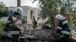 Rescue workers remove rubble at the site of a Russian missile strike in Kharkiv's Slobidskyi district on August 25, 2024.