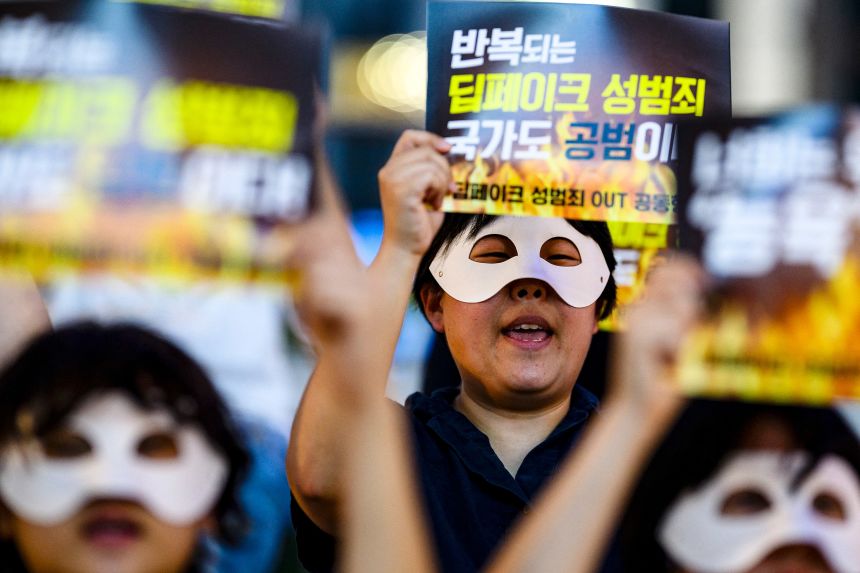 South Korean activists wearing eye masks hold posters reading 'Repeated deepfake sex crimes, the state is an accomplice too' during a protest against deepfake porn in Seoul on August 30, 2024.