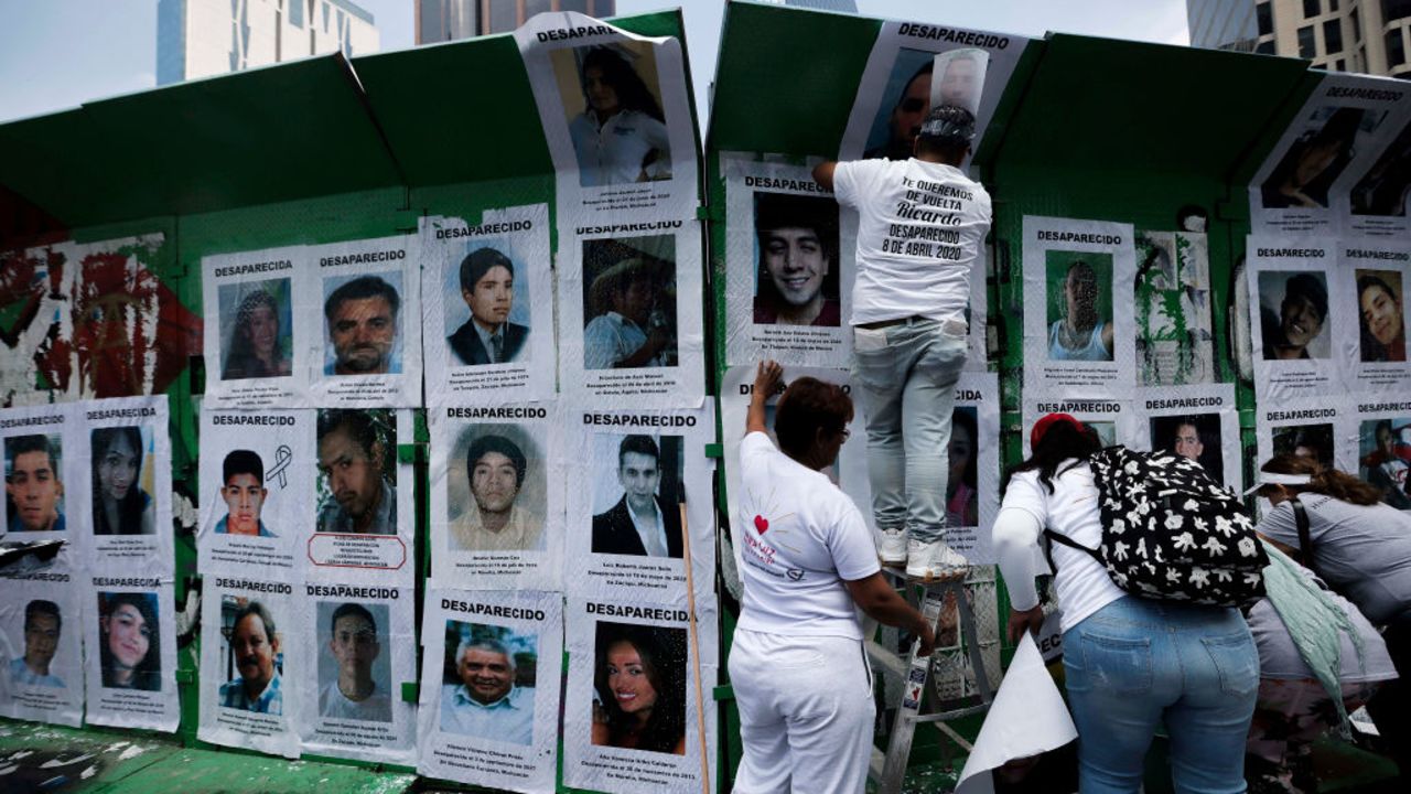 Members of different search collectives place portraits of missing people on a fence at La Glorieta de los Desaparecidos on Paseo de la Reforma avenue as part of the activities for the International Day of the Victims of Enforced Disappearances in Mexico City on August 30, 2024. (Photo by Rodrigo Oropeza / AFP) (Photo by RODRIGO OROPEZA/AFP via Getty Images)