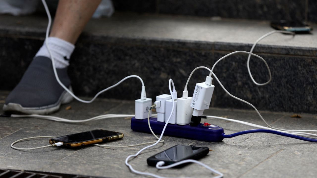 People charge their phones from an electric power generator during a blackout in Caracas on August 30, 2024. A blackout early Friday morning left Venezuela, including the capital, Caracas, in darkness, reported the government, which attributed the failure to a "sabotage" of the system by the opposition in the midst of its claims of electoral fraud. (Photo by Pedro Rances Mattey / AFP) (Photo by PEDRO RANCES MATTEY/AFP via Getty Images)