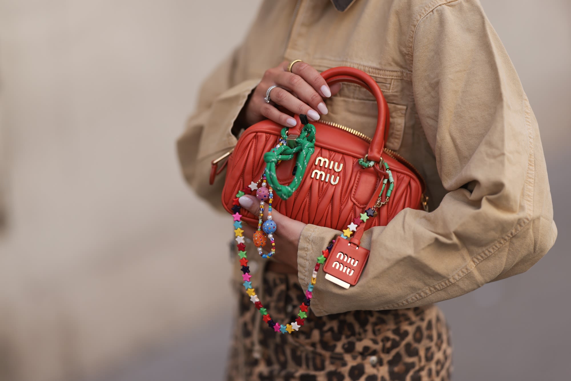 An orange Miu Miu Arcadie bag decked out in charms.