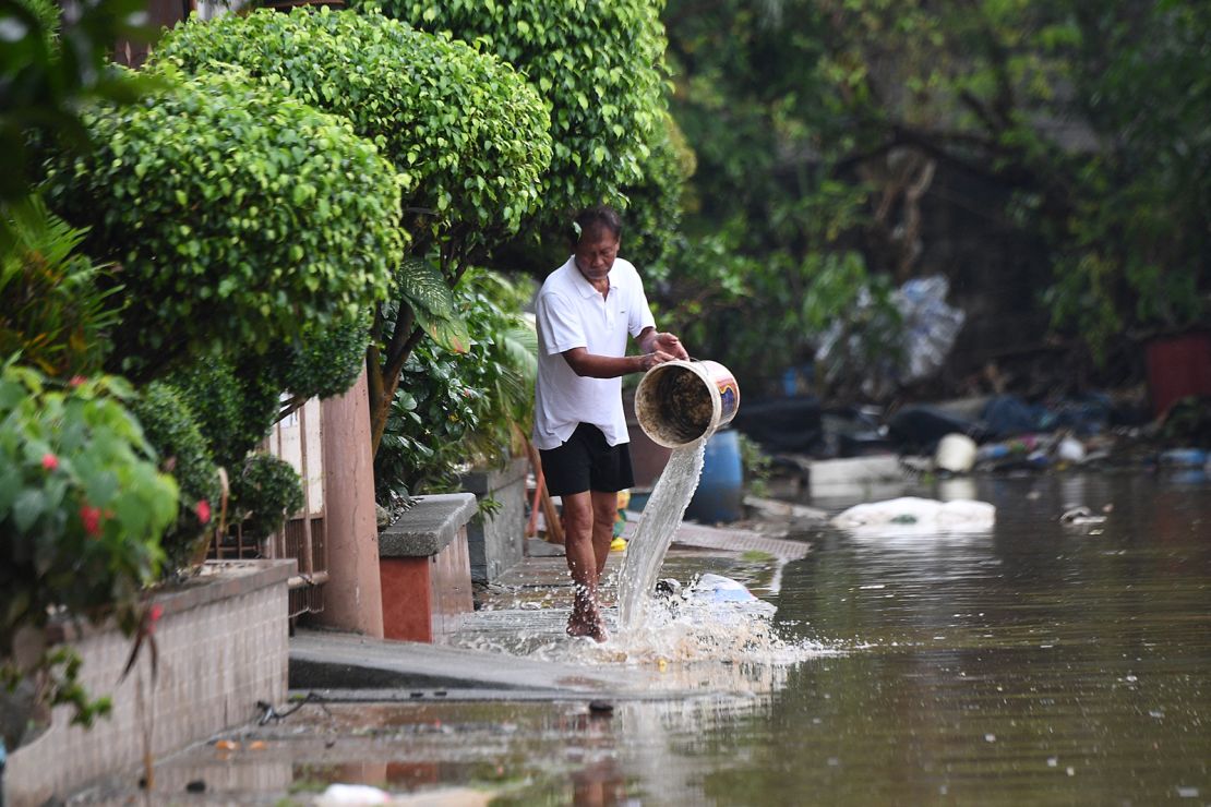 A man tries to remove water from his flooded home in Rizal province, Philippines on September 3, 2024.