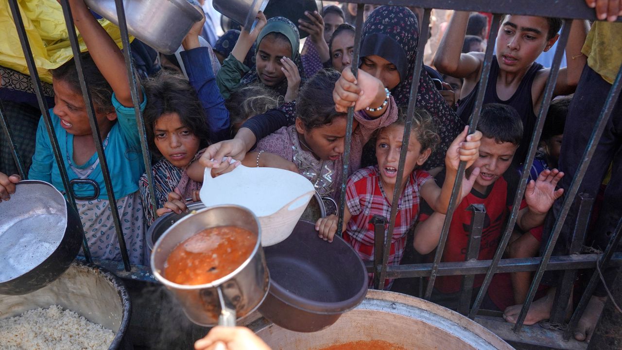 Palestinians receive food at a displacement camp in Khan Younis, Gaza, on September 3.