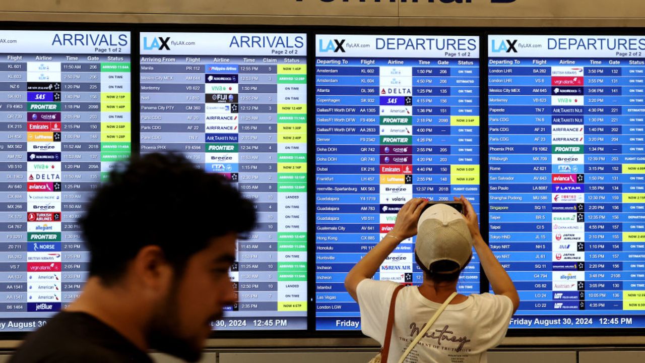 LOS ANGELES, CALIFORNIA - AUGUST 30: A person takes a photo of the departures board outside the international terminal at Los Angeles International Airport (LAX) ahead of the Labor Day holiday on August 30, 2024 in Los Angeles, California. The Transportation Security Administration (TSA) predicts Labor Day weekend will be the busiest ever, with almost 2.9 million travelers expected to be screened in U.S. airports today. (Photo by Mario Tama/Getty Images)