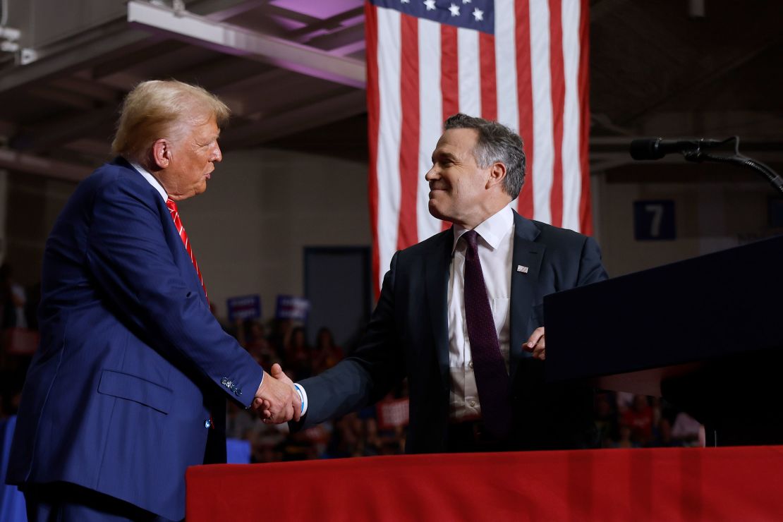 Republican presidential candidate and former president Donald Trump shakes hands with Republican U.S. Senate candidate David McCormick during a campaign rally on August 30, 2024 in Johnstown, Pennsylvania.