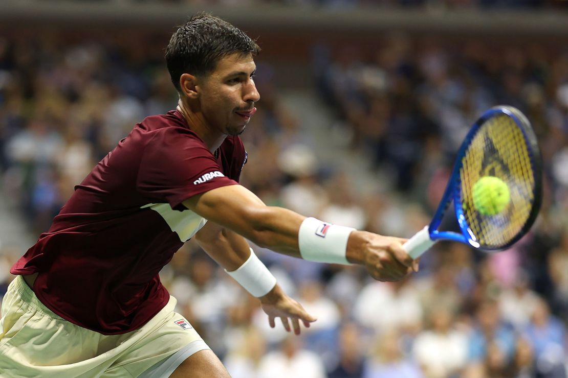 Popyrin returns a shot against Djokovic.