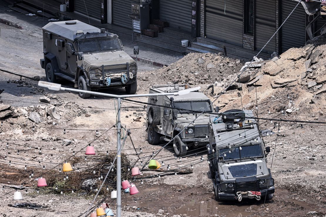 Israeli army armoured vehicles move along an excavated section of a road in the centre of Jenin in the occupied West Bank on Thursday amid ongoing military operations in the Palestinian territories.