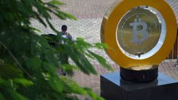 A man walks past a bitcoin monument at Plaza Bitcoin in San Salvador on September 4, 2024. According to the Institute for Public Opinion (IUDOP), Bitcoin adoption remains limited in El Salvador despite entering its third year as a legal currency. The NGO "My First Bitcoin" aims to promote cryptocurrency use by teaching it in public schools, with over 35,000 students attending their classes so far. While 88 out of 100 people reported not using Bitcoin in 2023, some, like taxi driver Napoleon Osorio, have embraced it in their businesses. "I started on my own" three years ago "and now manage 21 drivers," Osorio says. (Photo by Marvin RECINOS / AFP) (Photo by MARVIN RECINOS/AFP via Getty Images)