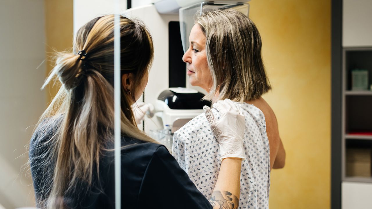 A nurse provides assistance to a patient undergoing a mammogram in a modern medical facility. The image highlights the importance of early detection and compassionate care in healthcare.