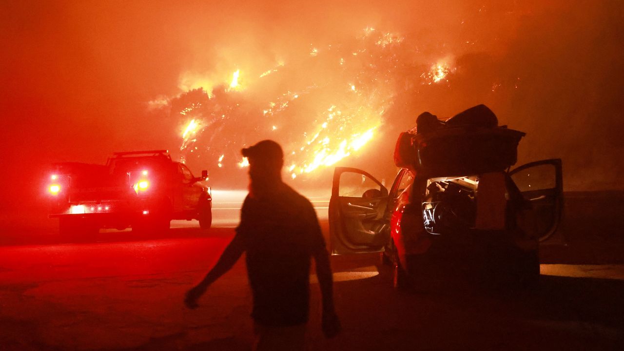 A resident walks by his car packed with belongings as Highway 330 is engulfed by the Line Fire near Running Springs, California, on September 7, 2024. California Governor Gavin Newsom and San Bernardino County authorities declared a state of emergency on September 8. The Line Fire has burned more than 7,000 acres (2,800 hectares). (Photo by DAVID SWANSON / AFP) (Photo by DAVID SWANSON/AFP via Getty Images)