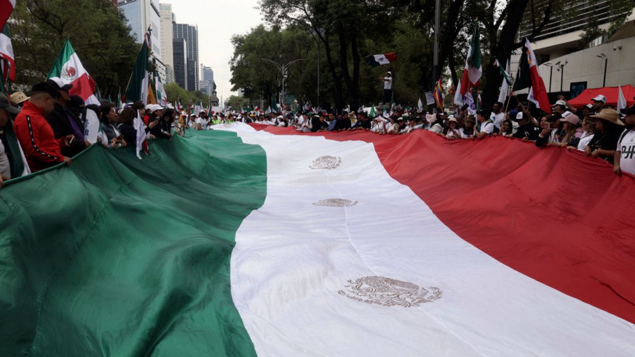 Students and workers of the Judiciary wave a Mexican flag in front of the Senate of the Republic during a march against the judicial reform proposed by the Mexican government in Mexico City on September 8, 2024. Mexico's outgoing President Andres Manuel Lopez Obrador warned the Supreme Court against blocking his controversial judicial reforms, saying it would be a "flagrant violation" of the constitution. The proposals, which would see Supreme Court and other judges selected by popular vote, have sparked diplomatic tensions with the United States, prompted protests by opponents, and upset financial markets. (Photo by Silvana FLORES / AFP) (Photo by SILVANA FLORES/AFP via Getty Images)