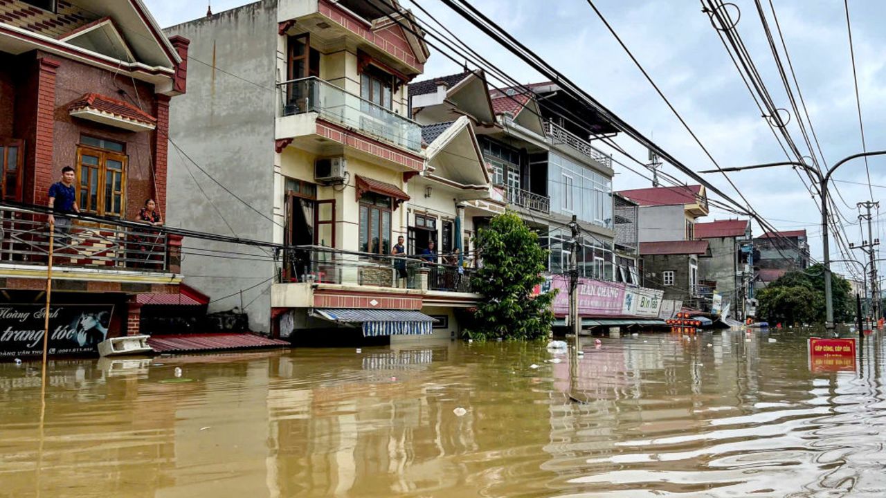 TOPSHOT - People stand on their balcony above a flooded street in Trang Dinh district, Lang Son province, on september 9, 2024, after Typhoon Yagi swept through northern Vietnam. The death toll from Typhoon Yagi jumped to 59 in Vietnam, state media said on September 9, 2024, as business leaders say the storm had been a "disaster" for the country's vital manufacturing sector. (Photo by Thu Huong / AFP) (Photo by THU HUONG/AFP via Getty Images)