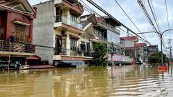 TOPSHOT - People stand on their balcony above a flooded street in Trang Dinh district, Lang Son province, on september 9, 2024, after Typhoon Yagi swept through northern Vietnam. The death toll from Typhoon Yagi jumped to 59 in Vietnam, state media said on September 9, 2024, as business leaders say the storm had been a "disaster" for the country's vital manufacturing sector. (Photo by Thu Huong / AFP) (Photo by THU HUONG/AFP via Getty Images)