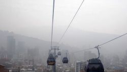 Cable car cabins descend from El Alto to La Paz, mostly covered by smoke from forest fires in eastern Bolivia, on September 9, 2024. (Photo by JORGE BERNAL / AFP) (Photo by JORGE BERNAL/AFP via Getty Images)