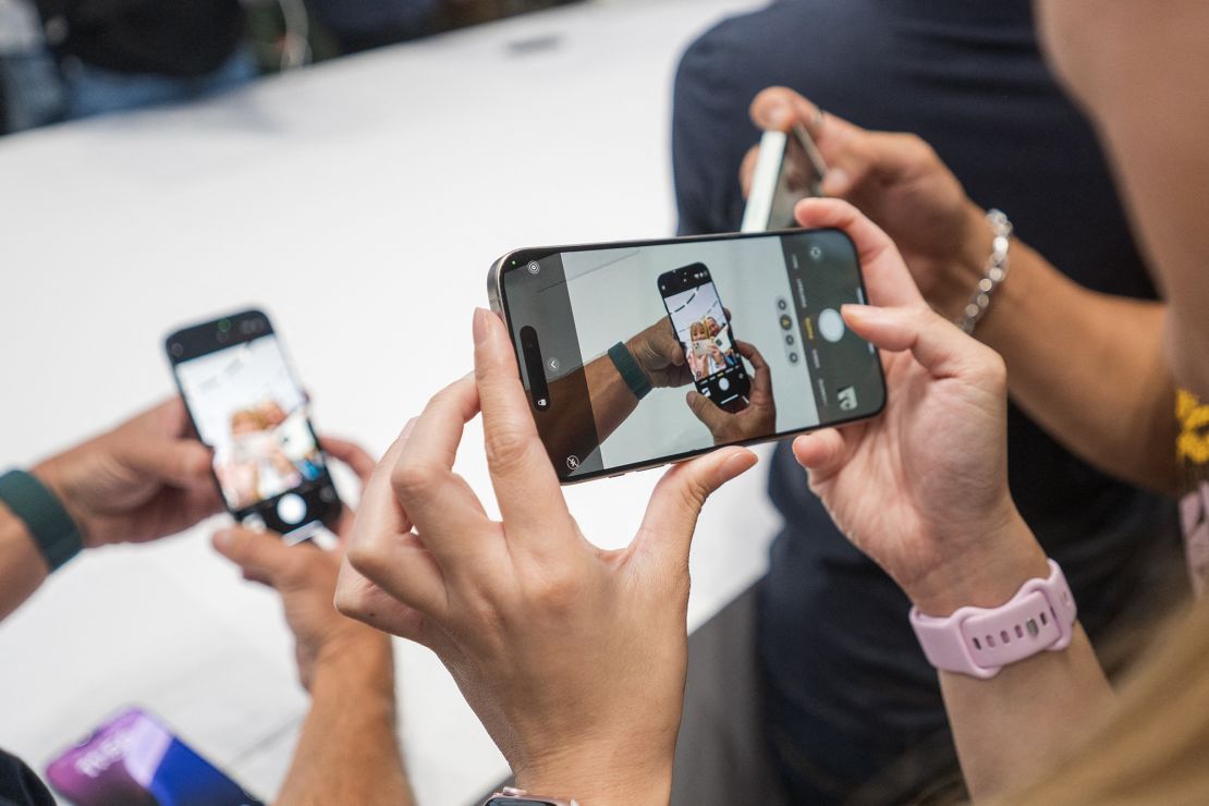 A woman takes a video of the new iPhone 16 Pro after Apple's 