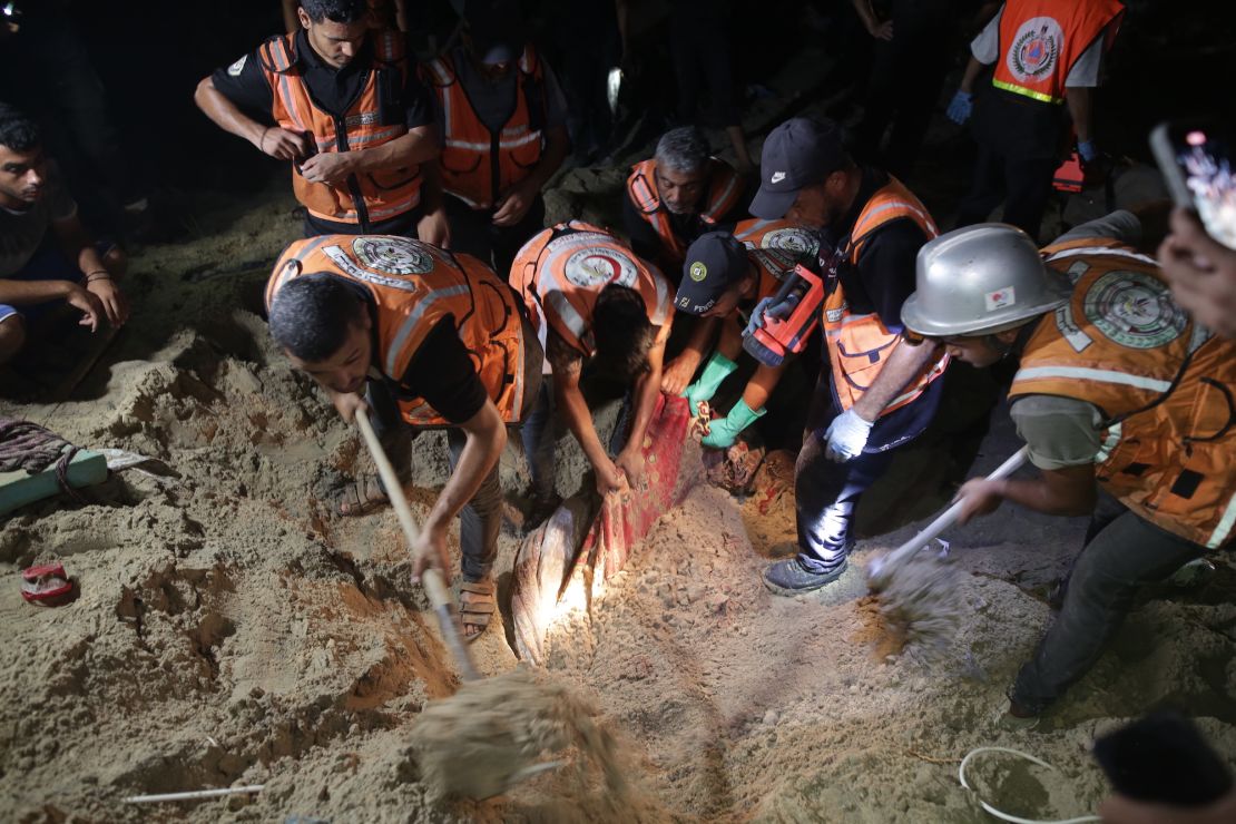 Teams conduct a search and rescue operation after Israeli airstrikes on a tent encampment of displaced Palestinians in Al-Mawasi, Gaza.