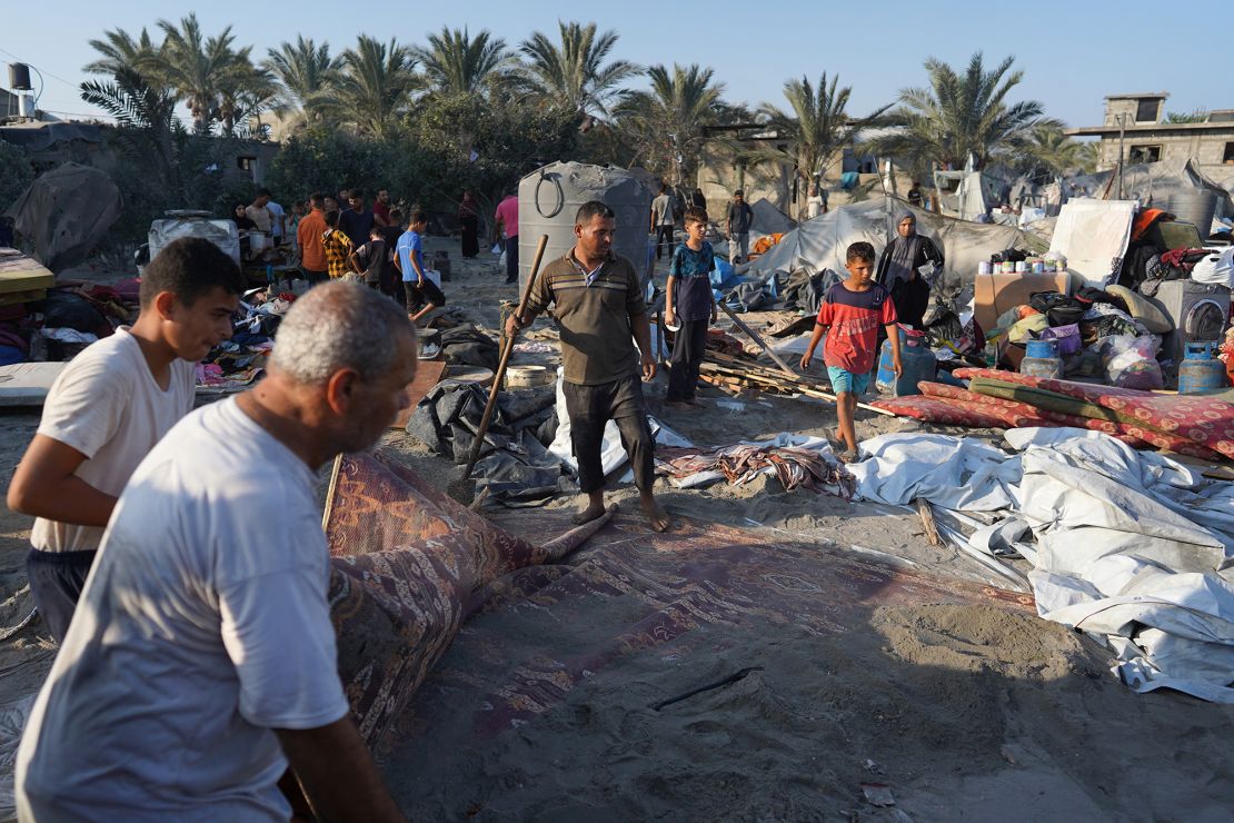 Palestinians gather their belongings at the site of Israeli strikes on a makeshift displacement camp in Mawasi, Khan Younis on Tuesday.