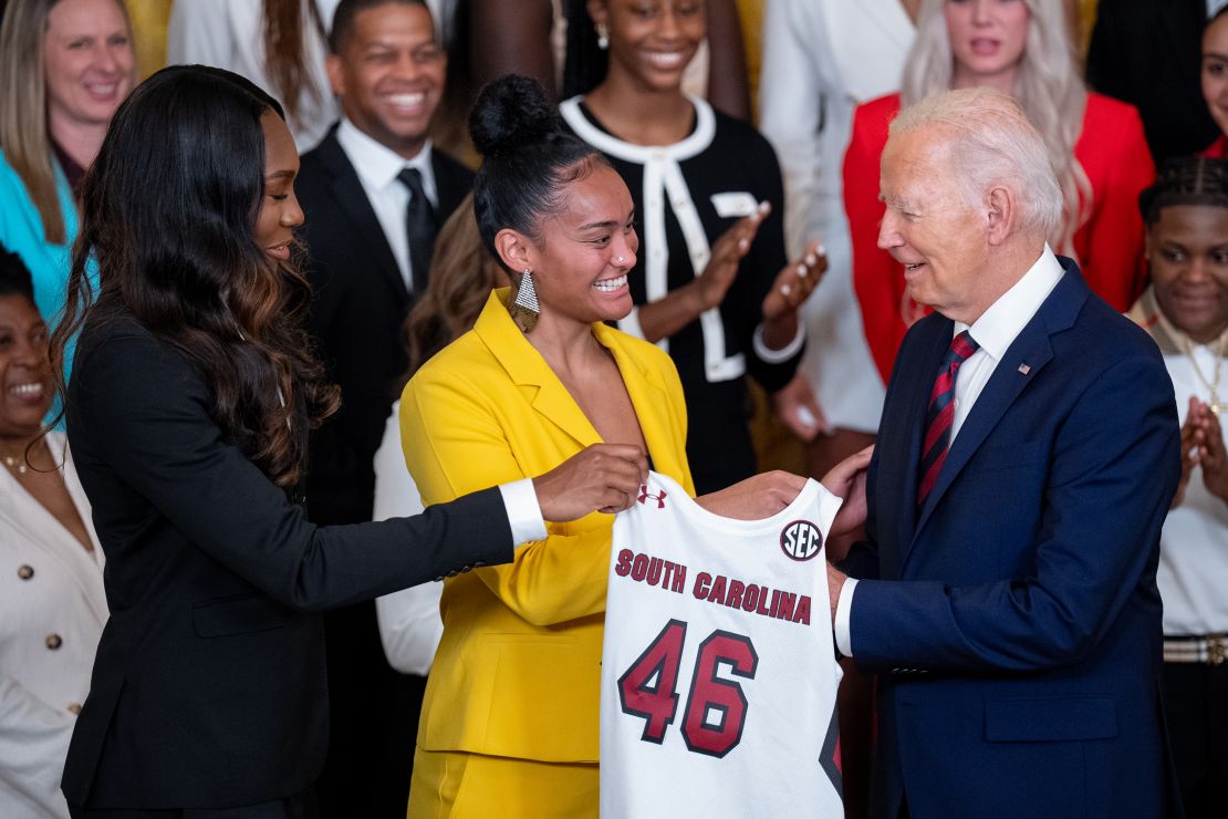 University of South Carolina basketball players Bree Hall (L) and Te-Hina Paopao (C) present President Joe Biden with a No. 46 Gamecocks jersey.