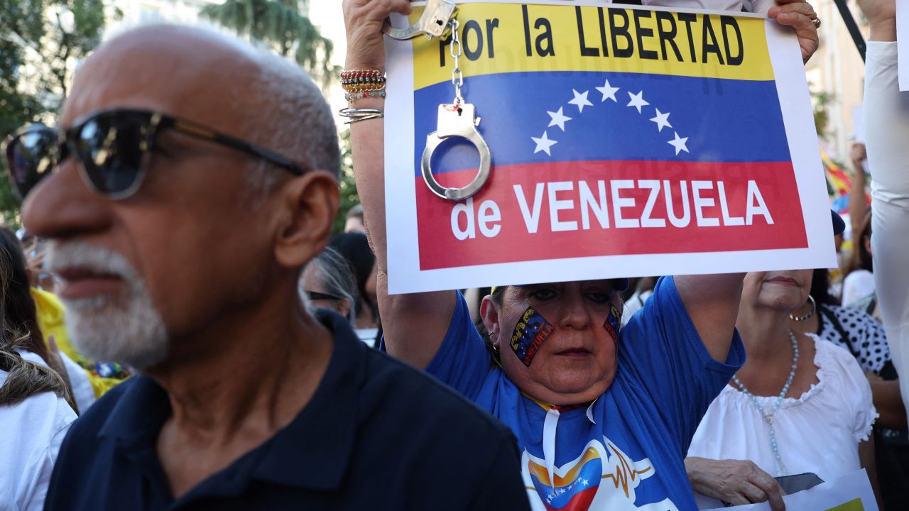 A Venezuelan opposition er holds a sign reading "For Venezuela's freedom" as they rally in front of the Spanish Parliament while Spanish MPs debate after Spanish right-wing PP party asked for the recognition by Spanish State of Edmundo Gonzalez Urrutia as the winner of the Venezuelan election at the Spanish Congress in Madrid on September 10, 2024. Venezuelan opposition presidential candidate Edmundo Gonzalez Urrutia, who contested incumbent Venezuelan President July 28 reelection, fled for exile in Spain on September 8, and vowed to "continue the fight" for freedom and democracy. Gonzalez Urrutia arrived in Madrid after weeks in hiding in the crisis-torn South American country. (Photo by Pierre-Philippe MARCOU / AFP) (Photo by PIERRE-PHILIPPE MARCOU/AFP via Getty Images)