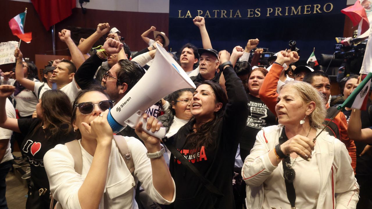 TOPSHOT - Demostrators take part in a protest inside the legislature's upper house during the legislation of the judicial reform proposed by the government at the National Congress in Mexico City on September 10, 2024. The Mexican Senate called for a session in an alternate venue to debate President Andres Manuel Lopez Obrador's controversial judicial reform after protesters invaded the legislative precinct and forced the suspension of deliberations, the chamber announced. (Photo by Silvana FLORES / AFP) (Photo by SILVANA FLORES/AFP via Getty Images)