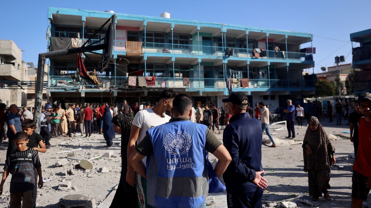 A member of the United Nations Relief and Works Agency for Palestine Refugees surveys damage in a school courtyard after an Israeli air strike hit the site, in Nuseirat, Gaza, on September 11.