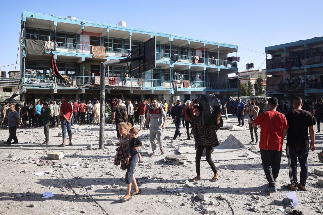 Palestinians walk in the courtyard of the Al Jaouni school after an Israeli air strike hit the site, in Nuseirat in the central Gaza Strip on September 11, 2024.