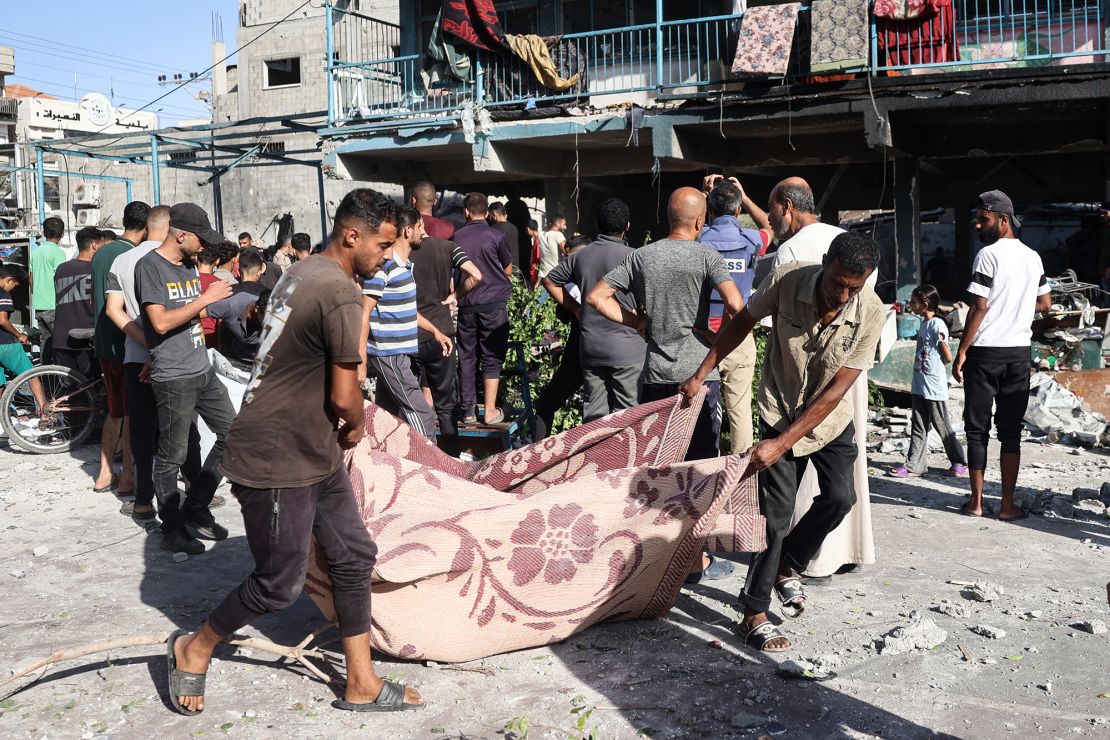 People use a blanket to transport a victim after an Israeli air strike hit the Al Jaouni school in Nuseirat, in the central Gaza Strip on September 11, 2024.