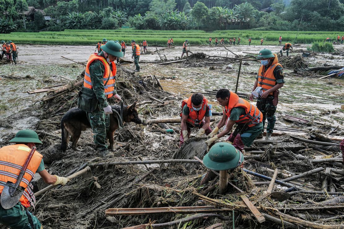 Rescue officials clean up debris from a landslide in a remote mountainous village in Vietnam's northwestern Lao Cai province on September 12, 2024.