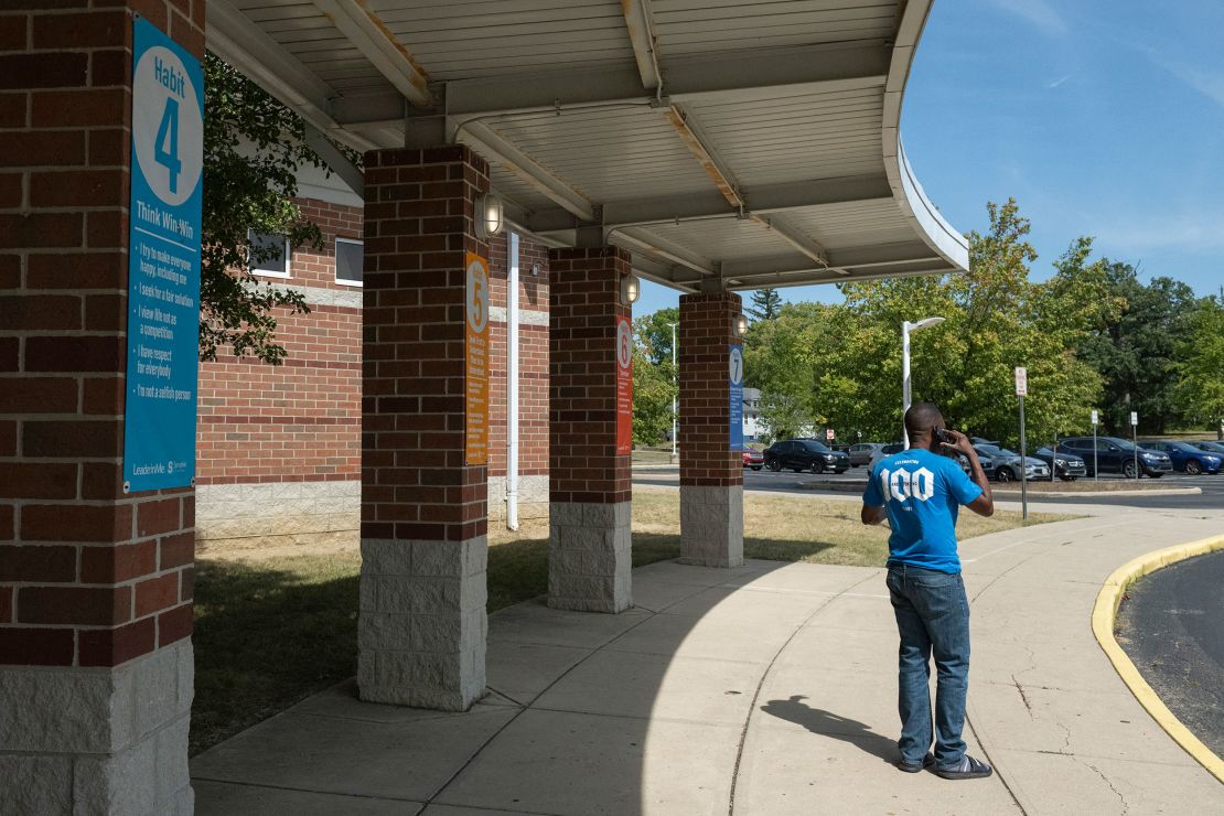 A father trying to pick up his child speaks on the phone in front of Fulton Elementary School after the school was evacuated following bomb threats on September 12, 2024.