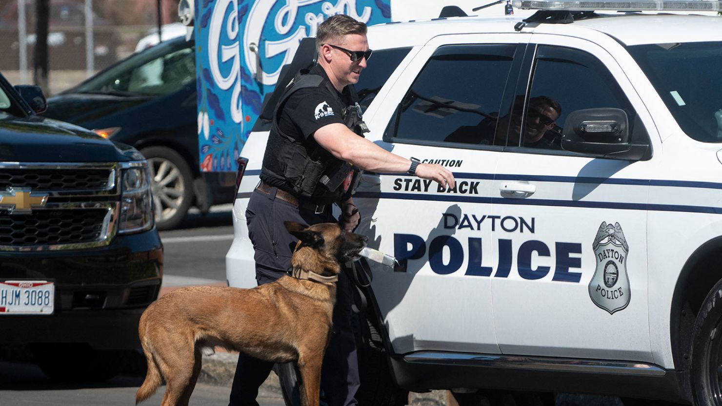 A police officer and his dog return to their vehicle after sweeping the Springfield City Hall grounds for explosives after bomb threats on September 12, 2024.