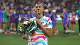 SAN DIEGO, CALIFORNIA - SEPTEMBER 08: Alex Morgan #13 of San Diego Wave FC holds a bouquet of flowers while speaking to the crowd after the game against the North Carolina Courage at Snapdragon Stadium on September 08, 2024 in San Diego, California. This was Morgan’s final NWSL game before her announced retirement. (Photo by Kaelin Mendez/Getty Images)