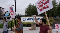 RENTON, WASHINGTON - SEPTEMBER 13: Boeing Machinists union members  Alex Garcia, right, Hossein Hosseini, center, and Molly Rimko picket outside of a Boeing Factory, September 13, 2024 in Renton, Washington. The union voted overwhelmingly to reject the airplane maker's contract offer and strike. (Photo by Stephen Brashear/Getty Images)