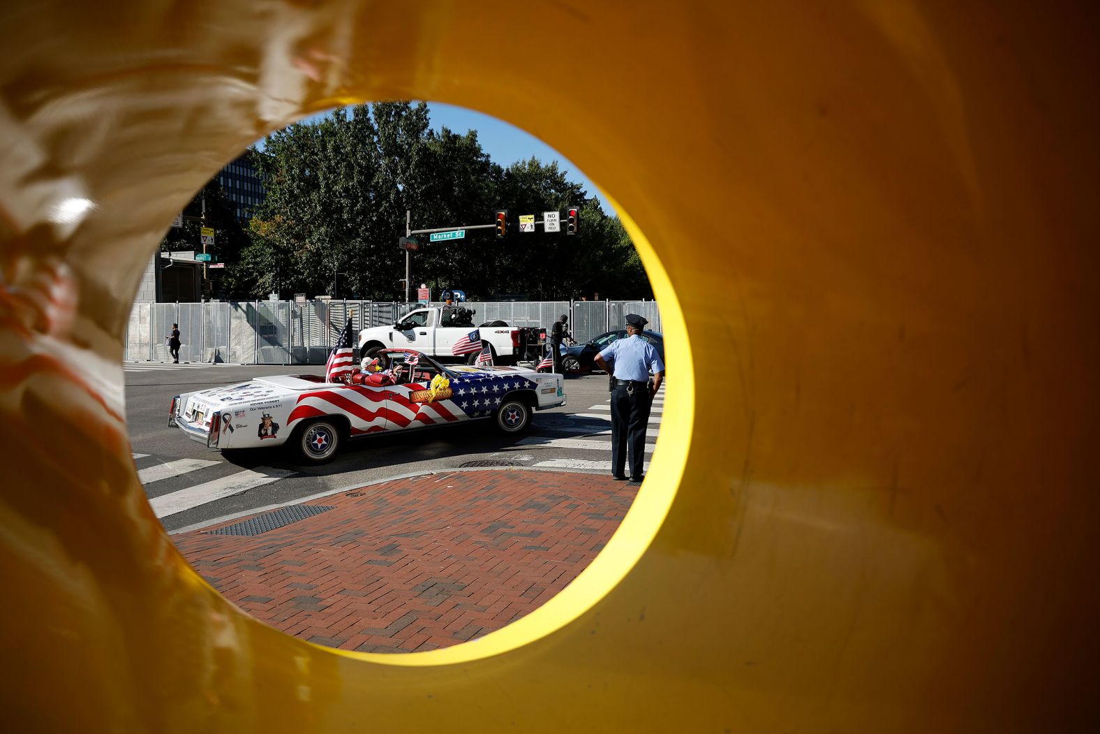 A car decorated with American flags drives past the metal fencing surrounding the National Constitution Center on Tuesday.