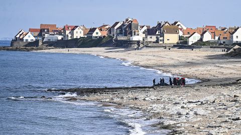 French gendarme use a tractor to pull a damaged migrants' boat after a failed attempt to cross the English Channel that led to the death of 8 people near the beach of Ambleteuse, northern France on September 15, 2024. Eight migrants died when their clandestine boat sank off Ambleteuse (Pas-de-Calais) on September 15, 2024, bringing to over 45 the number of would-be exiles to Britain who died in the Channel in 2024. (Photo by Bernard BARRON / AFP) (Photo by BERNARD BARRON/AFP via Getty Images)