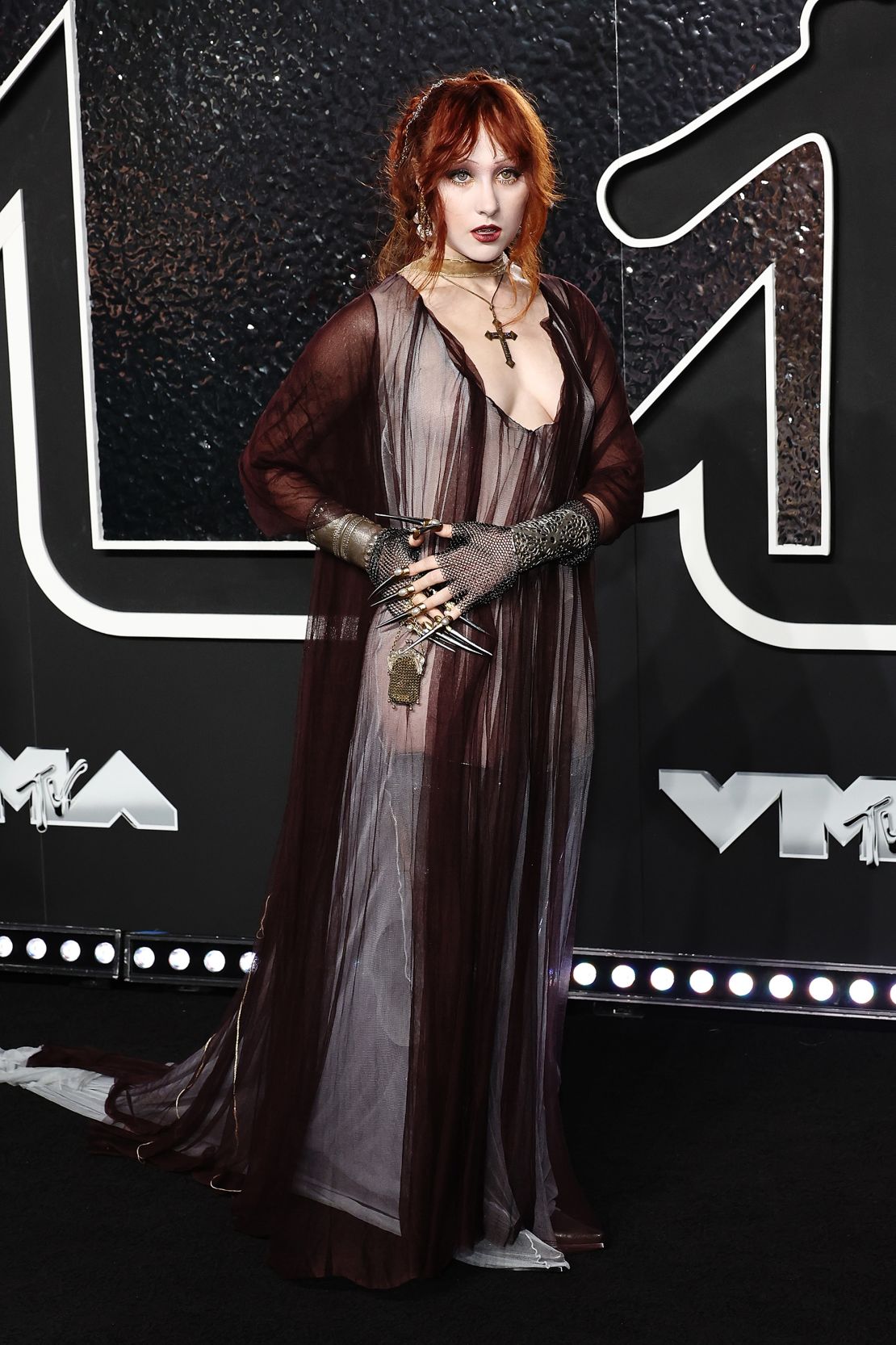 Chappell Roan paired her goth-inspired Y/Project gown with a cross pendant and dramatic nails emerging from chainmail fingerless gloves.