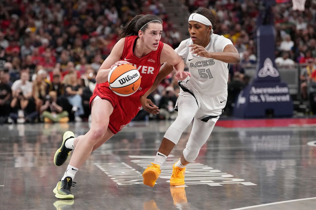 Caitlin Clark dribbles the ball while being guarded by Sydney Colson during the match.